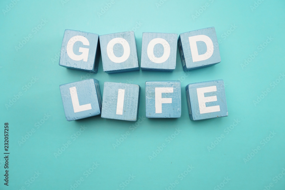 Obraz premium Dobre życie utworzone z liter alfabetu kostki na niebieskim tle