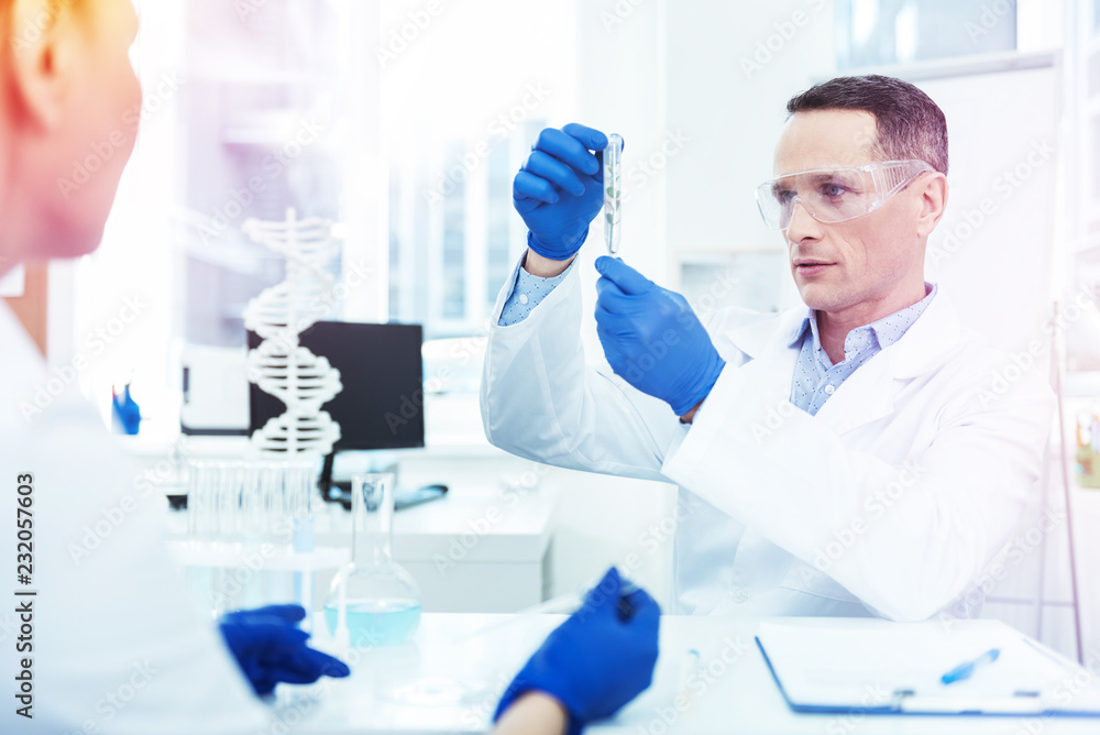 Serious handsome man wearing protective glasses in the lab Serious handsome man wearing protective glasses in the lab