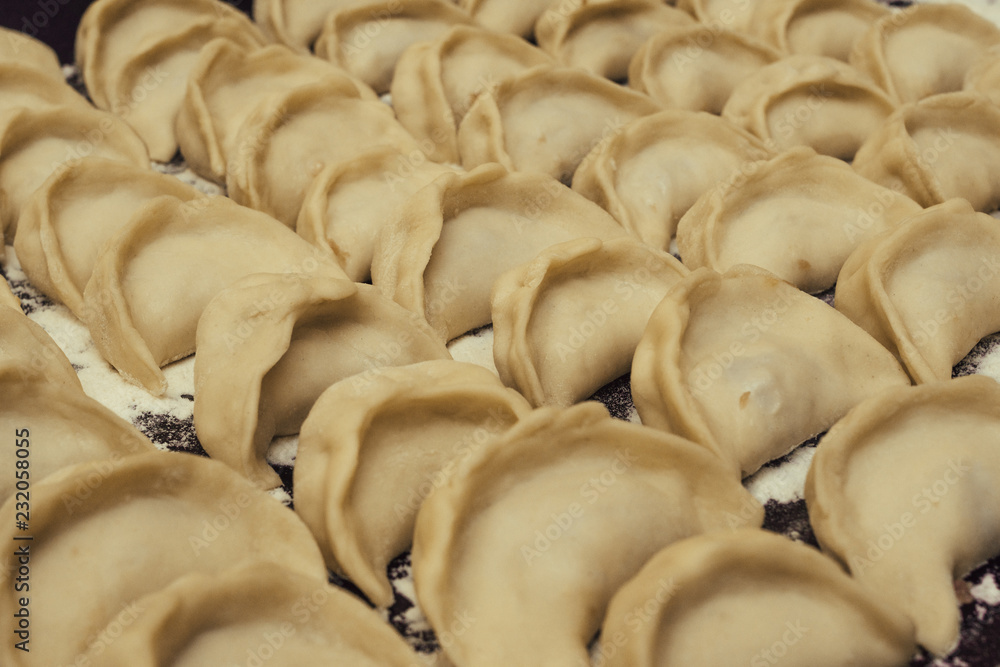 Obraz premium Dumplings pelmeni before cooking. Russian cuisine background