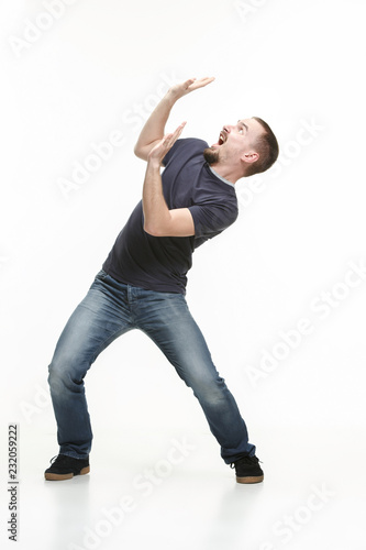 Vászonkép The young cool man full body scared pose at white studio