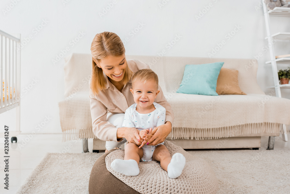 smiling mother hugging adorable toddler in nursery room smiling mother hugging adorable toddler in nursery room