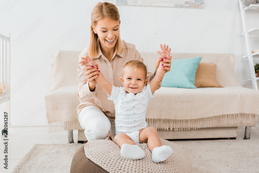 adorable toddler raising hands up with mother in nursery room adorable toddler raising hands up with mother in nursery room