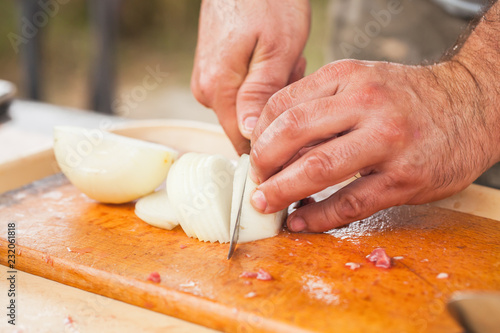 White onion slicing. Cook hands with knife