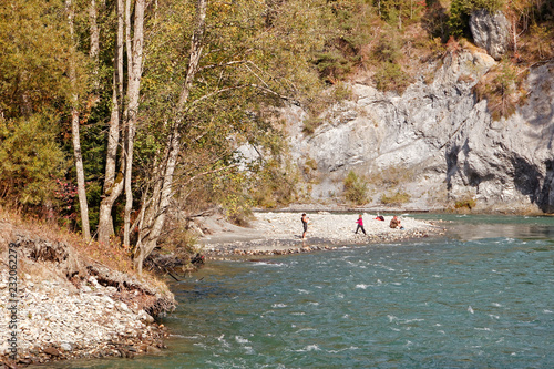 Family enjoying sunny day at banks for Rhine in autumnal Ruinaulta - Rheinschlucht (Rhine canyon) near Versam-Safien, Switzerland photo