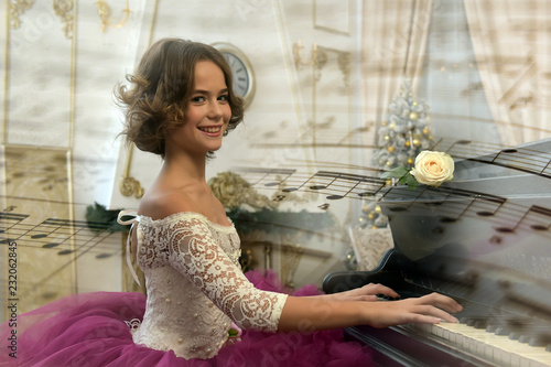 Girl in fluffy purple dress sits at old piano photo