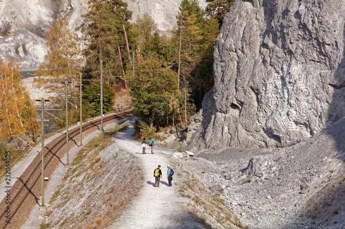 Tourists approaching Versam-Safien train station in sunny autumnal Ruinaulta - Rheinschlucht (Rhine canyon), Versam, Switzerland photo