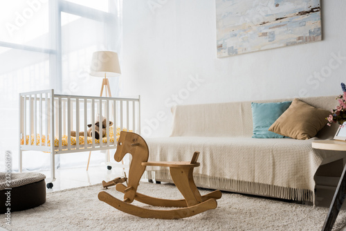 Valokuva modern interior design of nursery room with crib and rocking horse chair