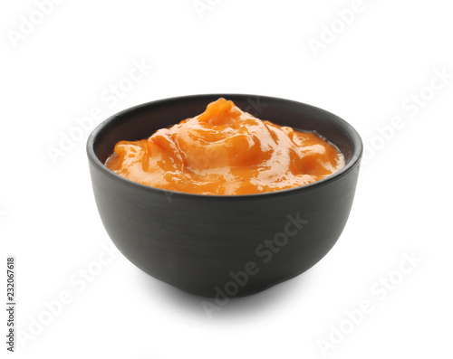 Tasty orange sauce in bowl on white background