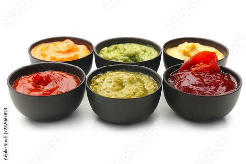 Different tasty sauces in bowls on white background photo