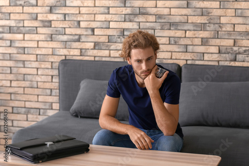 Depressed young man drinkin...