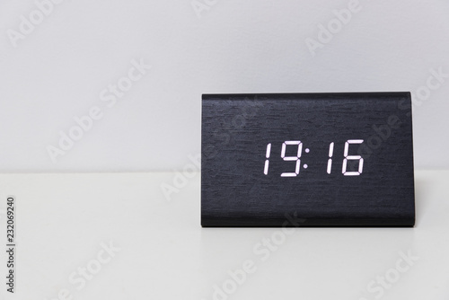 Black digital clock on a white background showing time 19:16 photo