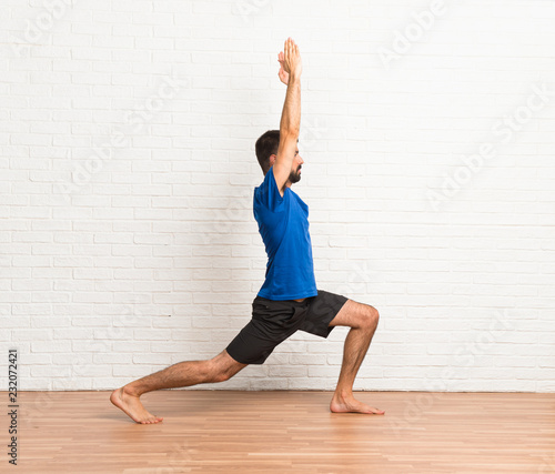 Man doing yoga exercises indoors