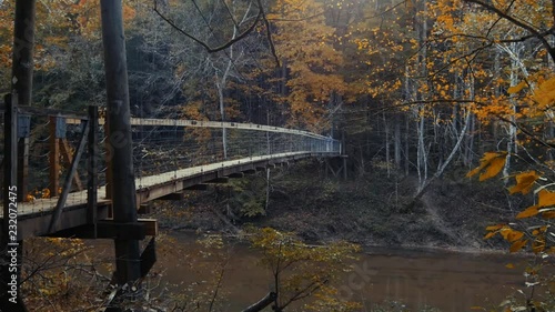 Hiker crossing Red River on suspension foot  bridge. photo