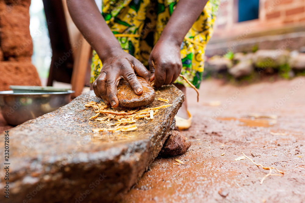 close up of african woman hands making traditional spices with homemade mortar in village close up of african woman hands making traditional spices with homemade mortar in village