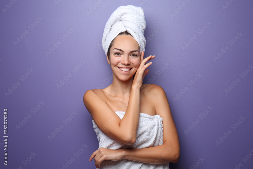 Beautiful young woman wrapped in towel on color background - obrazy, fototapety, plakaty 