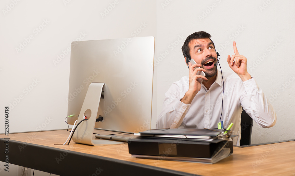 Telemarketer man in a office talking to mobile Telemarketer man in a office talking to mobile