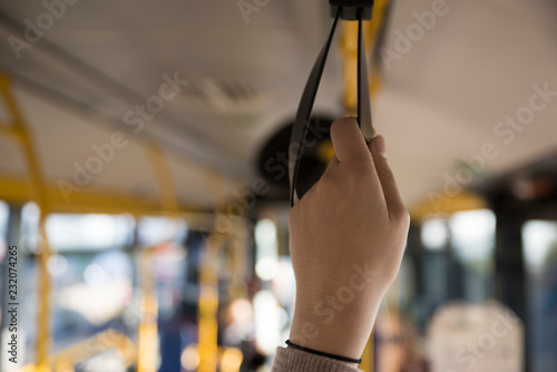 Girl holding on a handle on the bus