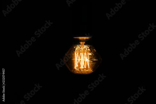 Glowing light bulb on dark background