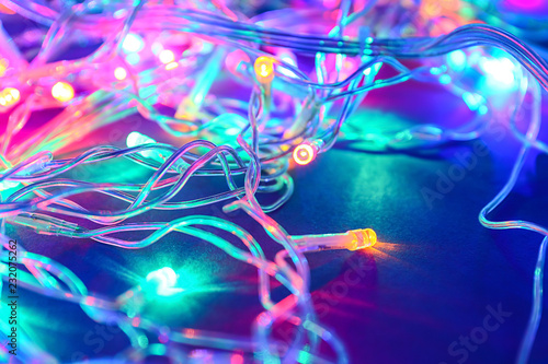 Glowing Christmas lights on dark background, closeup