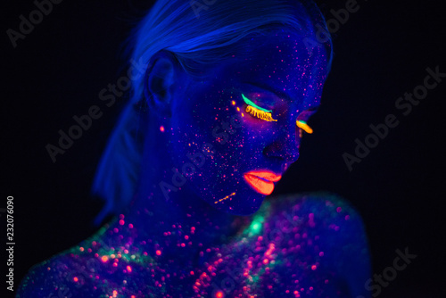Portrait of Beautiful Fashion Woman in Neon UF Light. Model Girl with Fluorescent Creative Psychedelic MakeUp, Art Design of Female Disco Dancer Model in UV, Colorful Abstract Make-Up