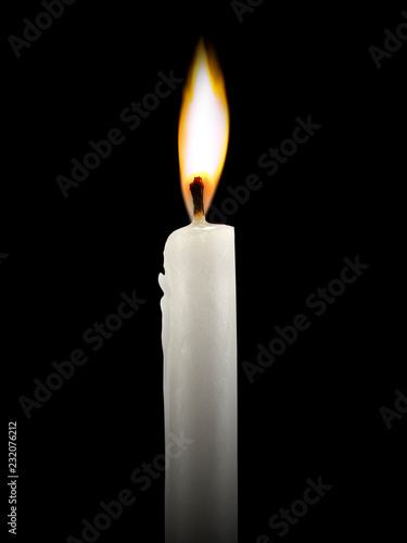 Candle burning brightly close up on the black background 