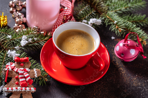 Coffee espresso, red cup of coffee and Christmas decorations on dark background.