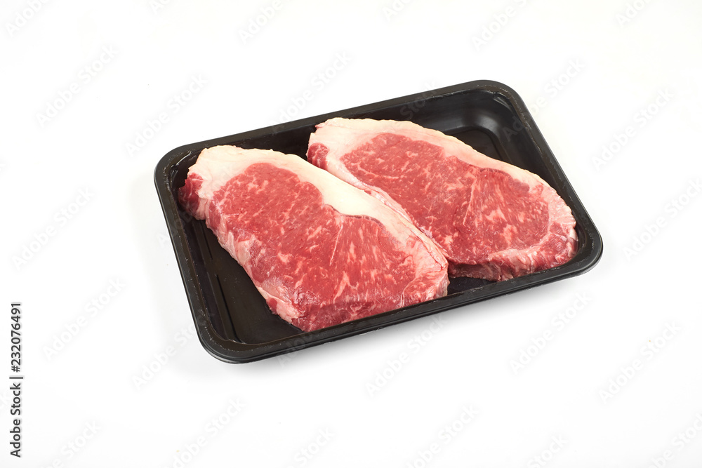 Raw sirloin beef steak in plastic packaging tray. Raw sirloin beef steak in plastic packaging tray.