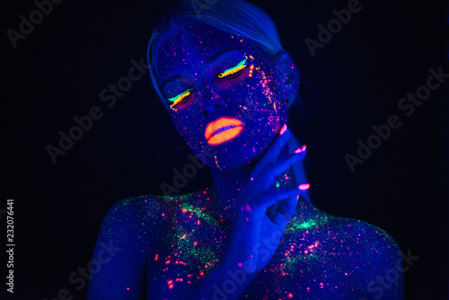 Portrait of Beautiful Fashion Woman in Neon UF Light. Model Girl with Fluorescent Creative Psychedelic MakeUp  Art Design of Female Disco Dancer Model in UV  Colorful Abstract Make-Up