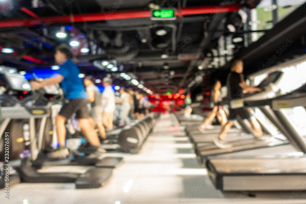 Blurred of fitness gym center interior background with two rows of cardio machine Blurred of fitness gym center interior background with two rows of cardio machine