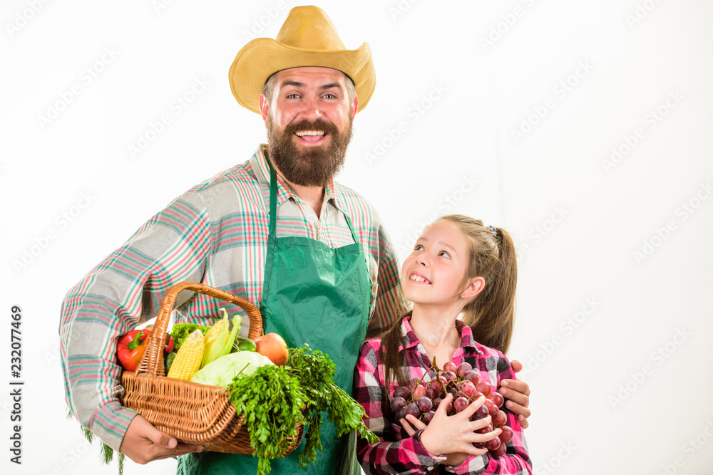 Fototapeta premium Farmers family homegrown harvest. Father farmer or gardener with daughter hold basket harvest vegetables. Gardening and harvesting. Family farm organic vegetables. Man bearded rustic farmer with kid