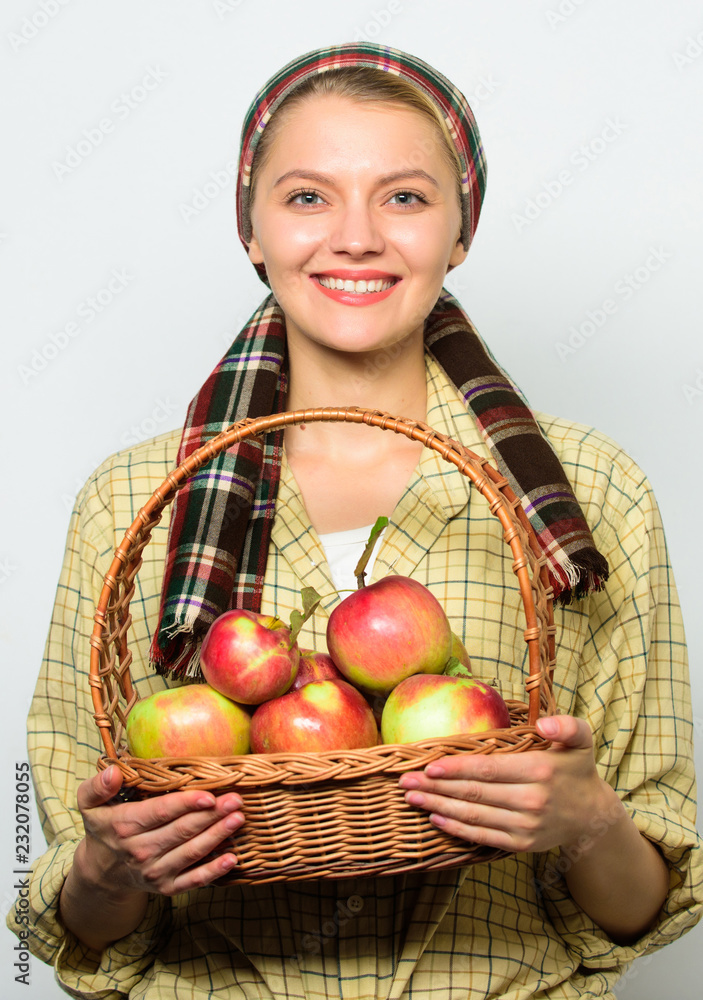 Lady farmer proud of her harvest. Apple crops and gardening concept. Woman cheerful carry basket with natural fruits. Woman gardener rustic style hold basket with apples harvest on light background Lady farmer proud of her harvest. Apple crops and gardening concept. Woman cheerful carry basket with natural fruits. Woman gardener rustic style hold basket with apples harvest on light background