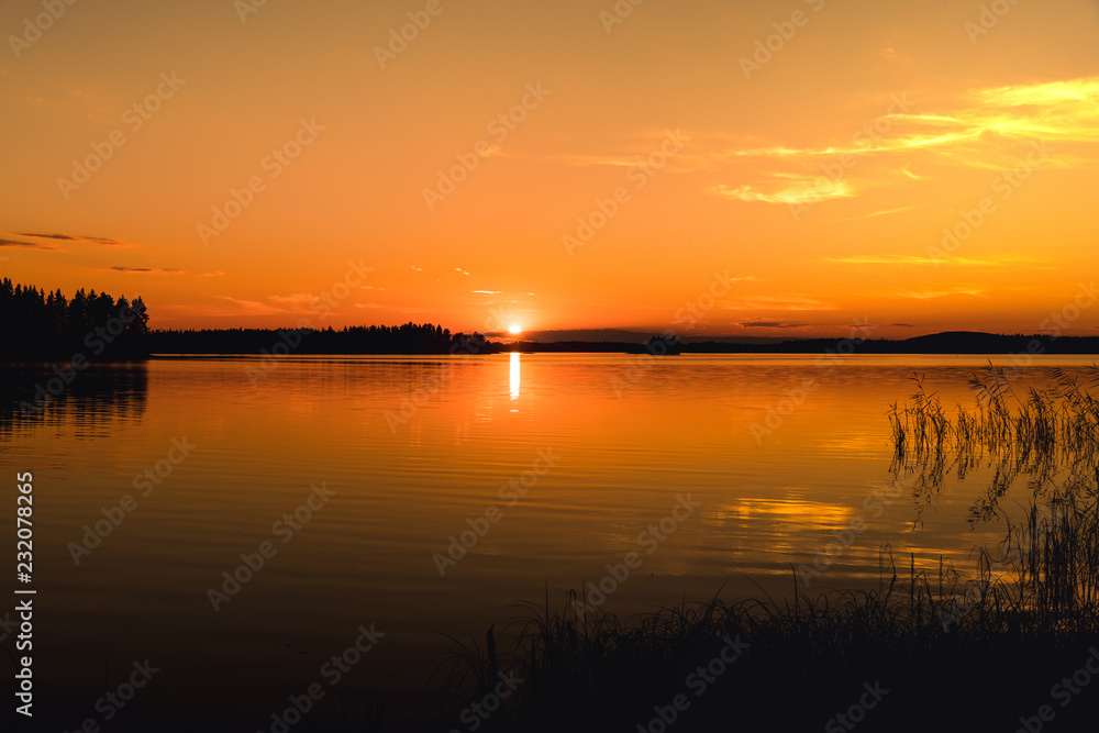 Beautiful bright orange sunset across a lake in Sweden
