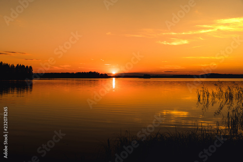 Beautiful bright orange sunset across a lake in Sweden