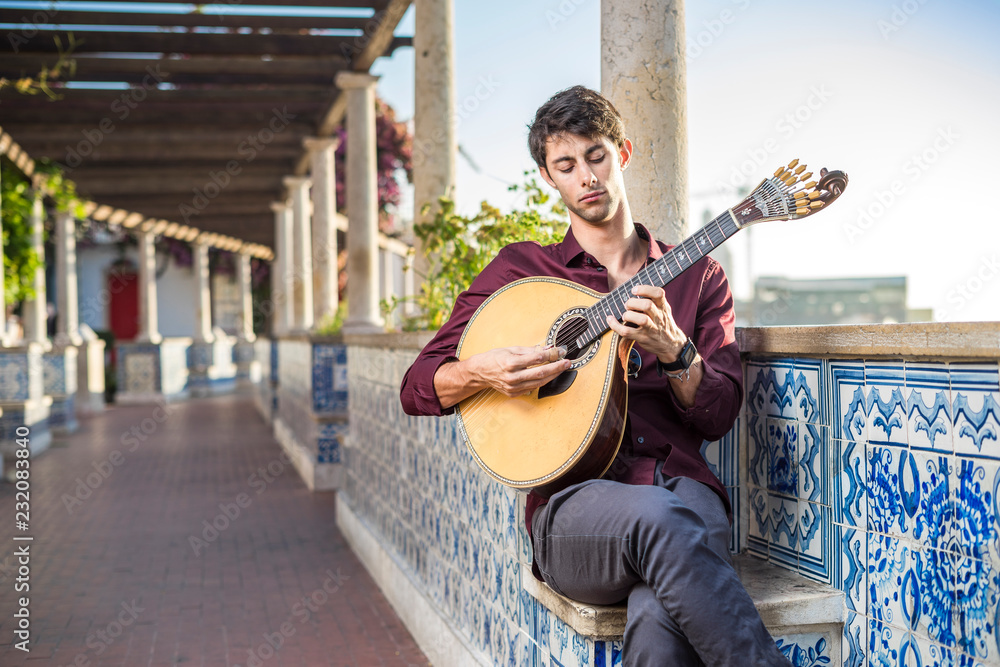 Fado musician playing on portuguese guitar in Lisbon, Portugal