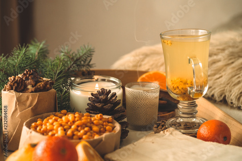 Still life with orange and sea buckthorn on a wooden background. Candle  tangerines.   Concept of seasonal vitamins 