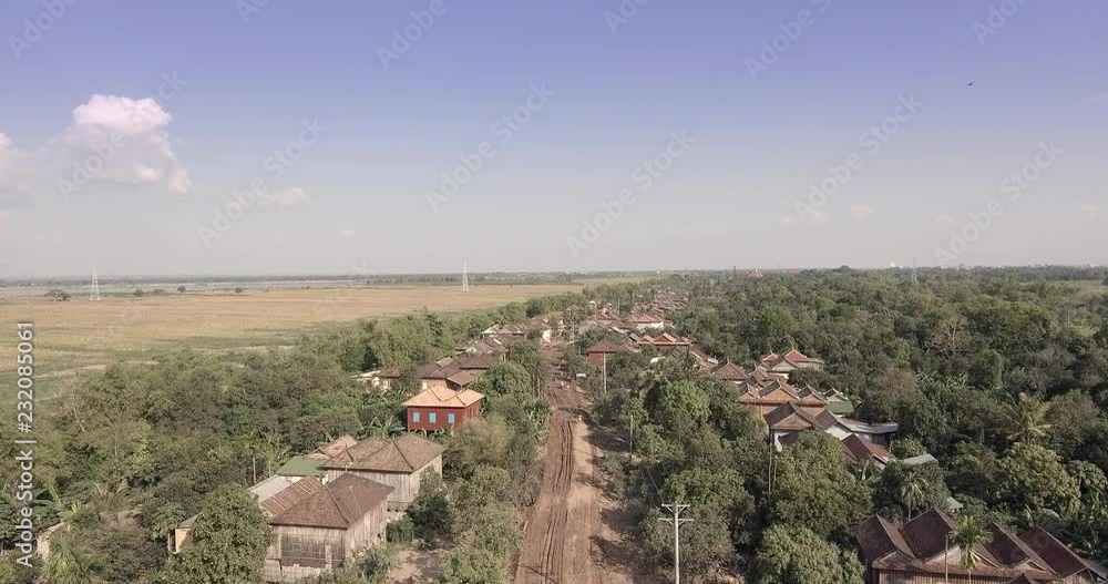 Aerial drone shot : fly over a dirt road and homes in small village Aerial drone shot : fly over a dirt road and homes in small village