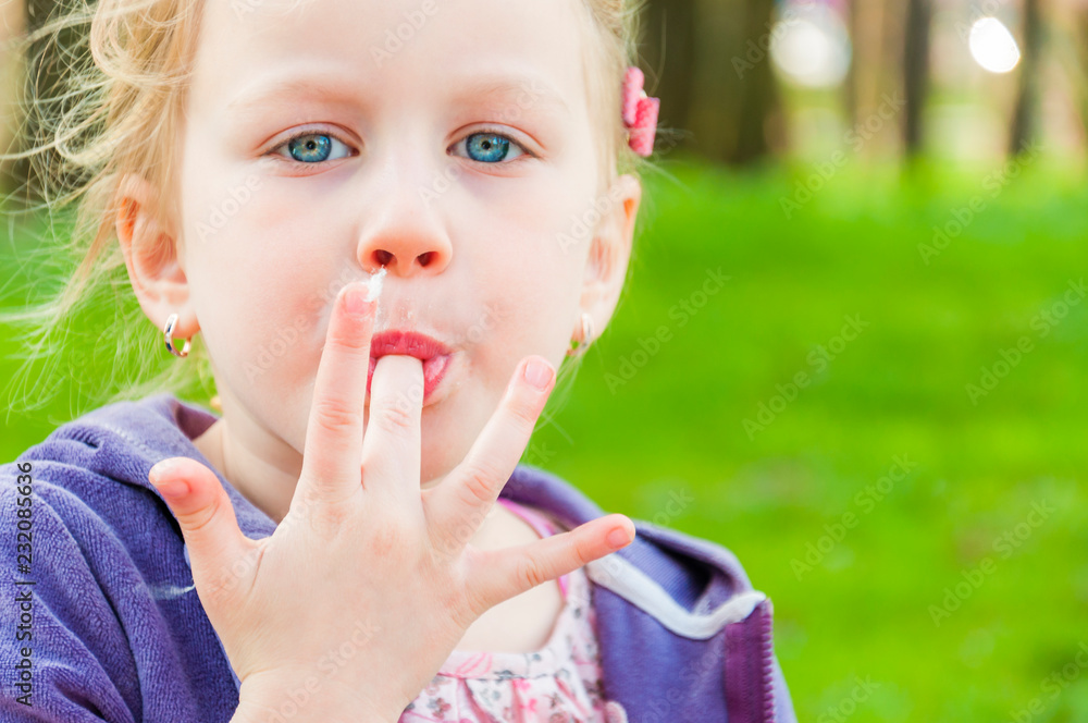 Blue-eyed blonde girl sucking long finger with candy-floss Blue-eyed blonde girl sucking long finger with candy-floss