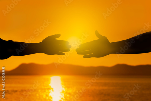 Silhouette of helping hand concept and international day of peace, Expression of Business Collaboration, Help hand, Teamwork concept, Business handshake ideas.