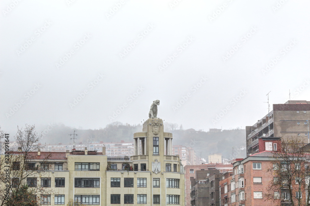 The modern Tiger Building (Edificio el Tigre) in Bilbao, Basque Country, Spain, during a foggy winter day, with a cloudy and rainy sky