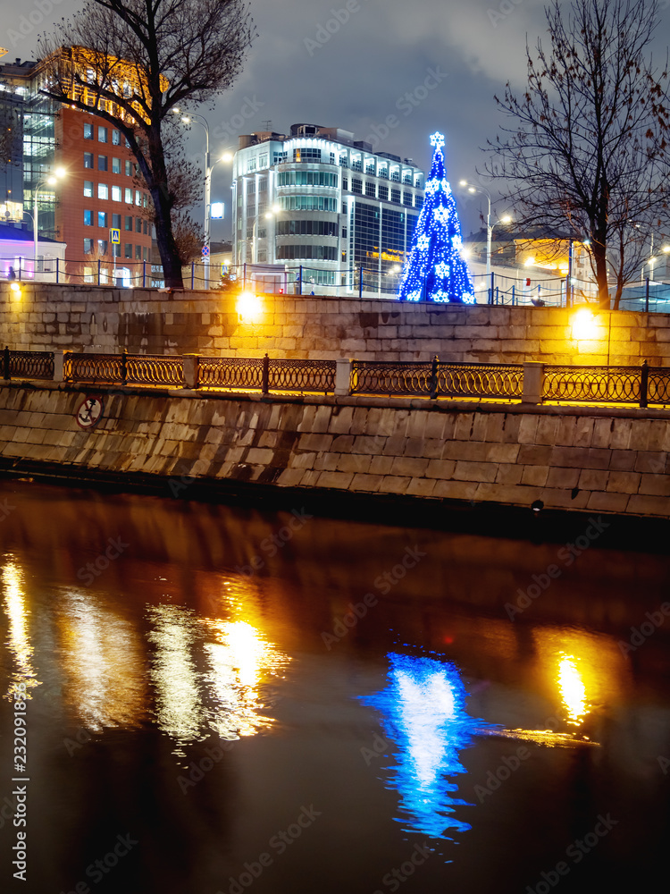 Illuminated Christmas tree Kosmodamianskaya embankment of Moscow-river. Moscow, Russia.