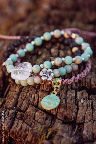 Three bracelets with gemstone beads on wooden background