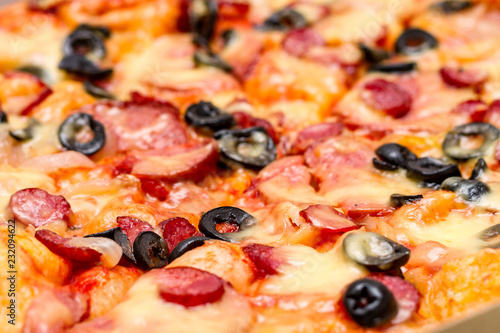 Pizza with salami, cheese and black olives. Selective focus. Close up.