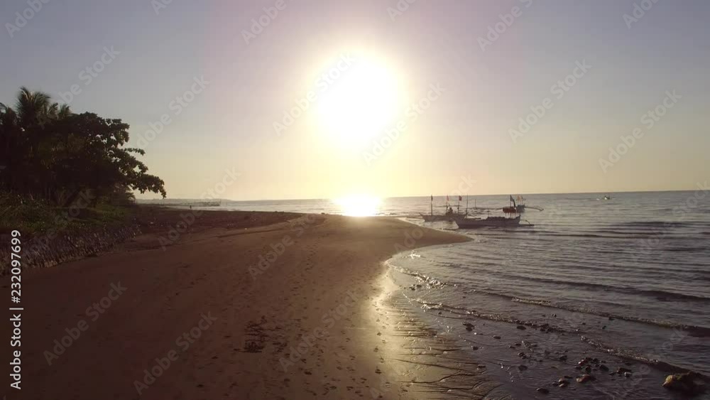 Exotic, romantic view of boat silhouette on a golden sunrise over sea shore. Drone aerial Exotic, romantic view of boat silhouette on a golden sunrise over sea shore. Drone aerial