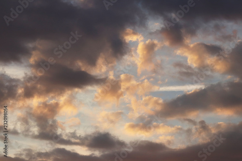 Sunset in the evening sky with golden clouds in the evening. Natural background for later design. Prediction of weather on the circulation of water in the atmosphere. Romantic mood. © Xato Lux