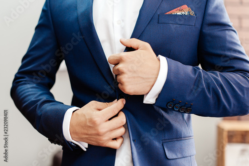 Man, groom buttoning blue jacket