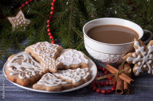Christmas composition with ginger cookies and a cup of cocoa on the background of spruce branches