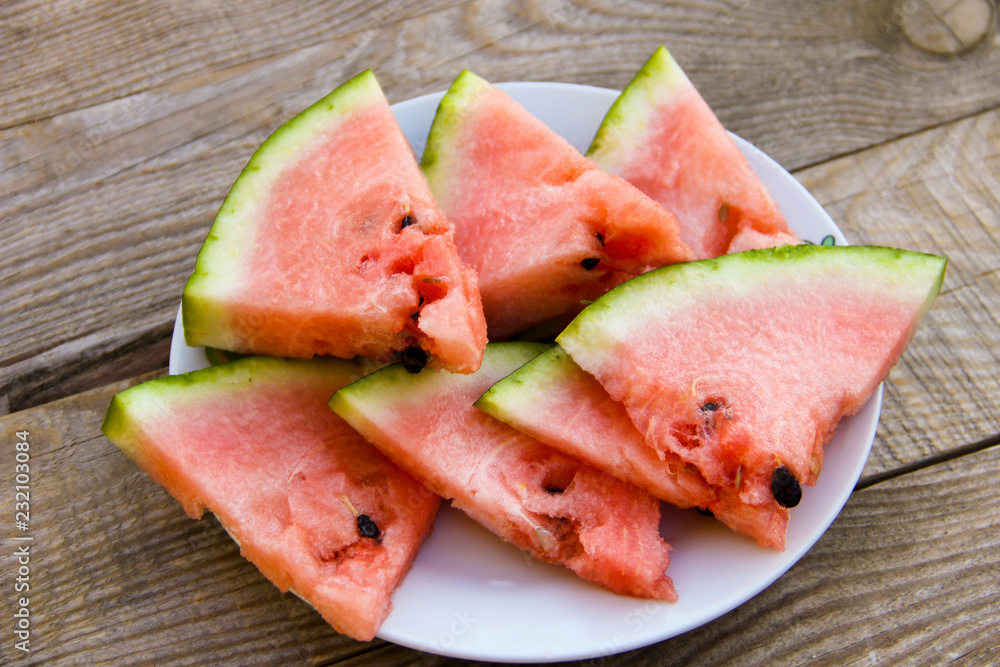 Sliced watermelon in a plate on wooden table Sliced watermelon in a plate on wooden table