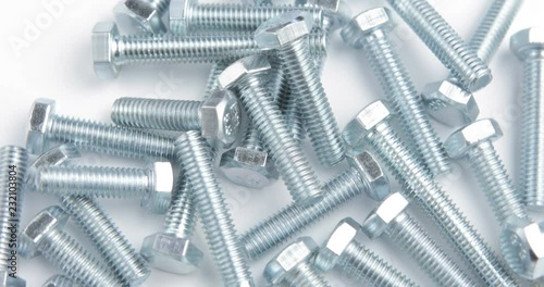 Stack of shiny screw, bolt or stud rotating on a white background