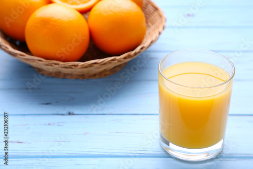 Glass of orange juice with orange on wooden table