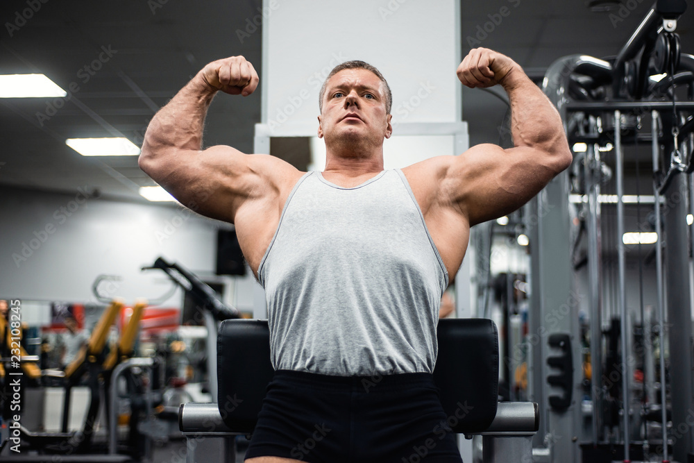 athletic man showing off his muscles at the gym athletic man showing off his muscles at the gym